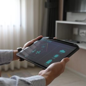 cropped-image-hands-are-using-tablet-with-home-devices-controlled-applications-screen-min