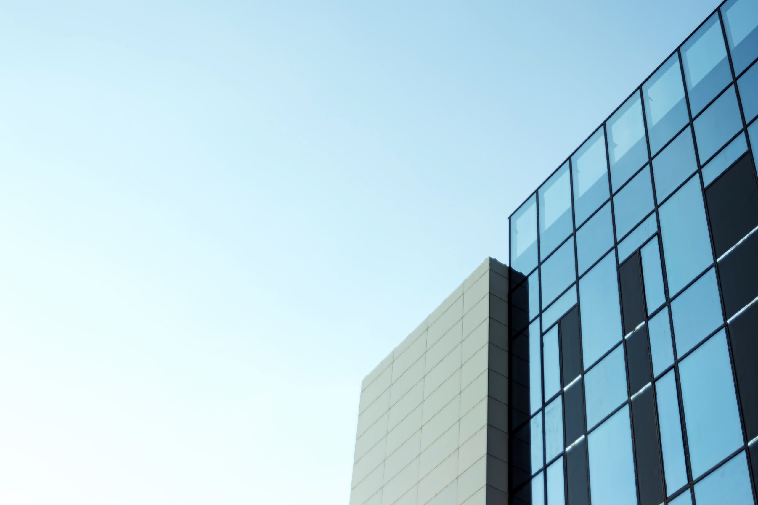 glass-office-building-view-sky-reflected-windows-min
