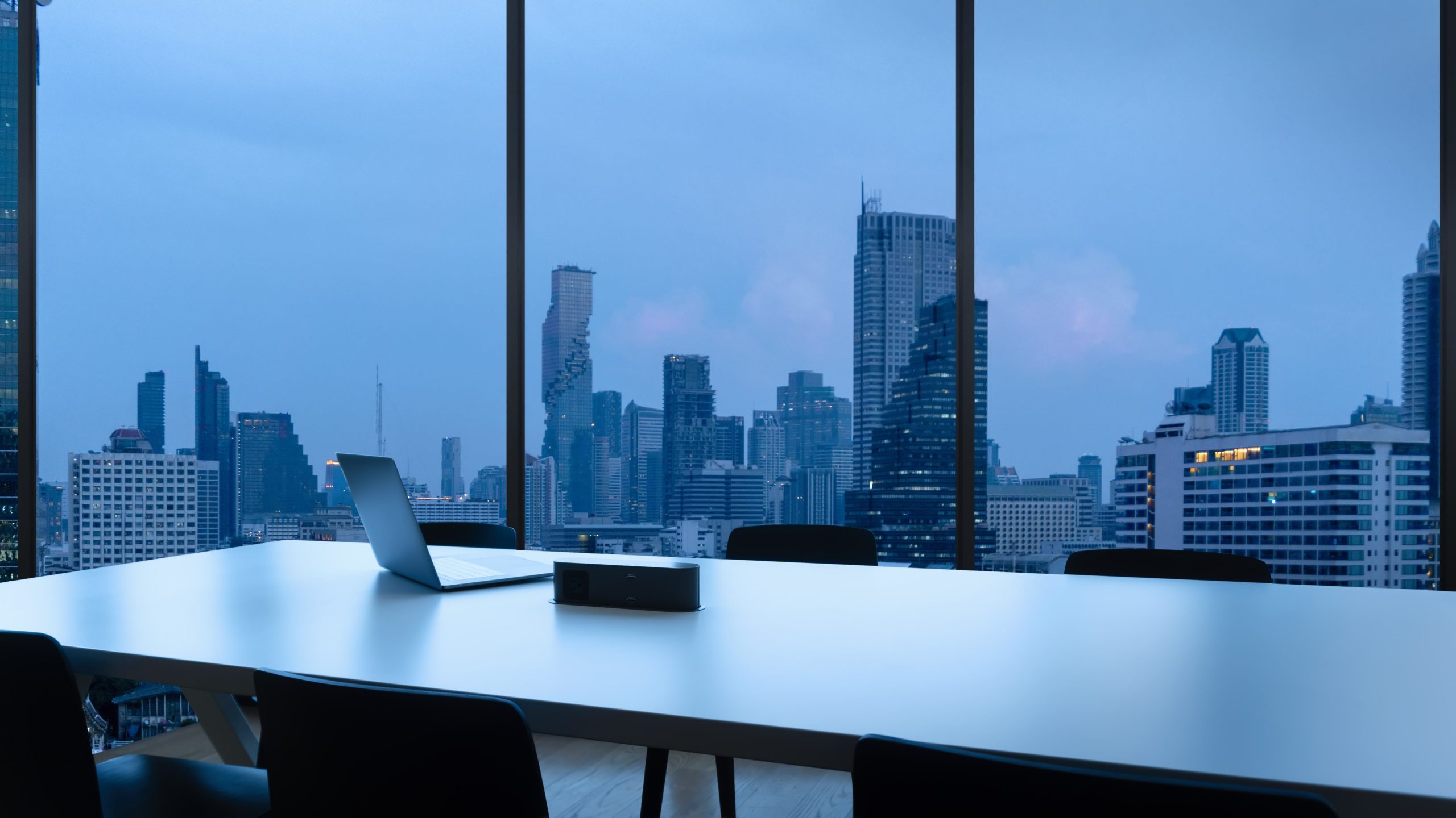 meeting-room-workplace-with-notebook-laptop-comfortable-work-table-office-windows-bangkok-city-view-min